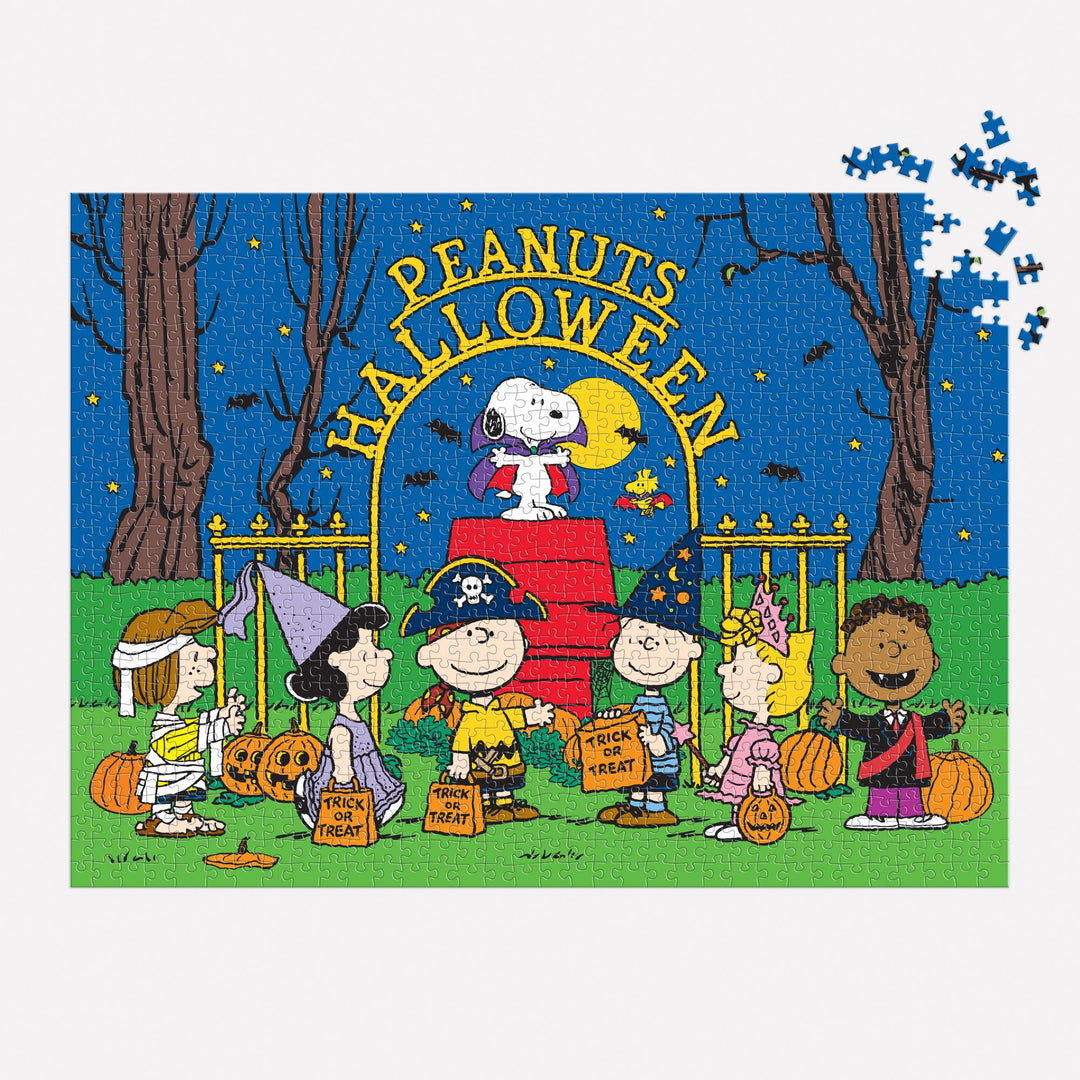 The Peanuts Halloween 1000 Piece Puzzle by Peanuts Worldwide, LLC shows Charlie Brown and friends in costumes trick-or-treating with Snoopy as the Red Baron and “Peanuts Halloween” above. A few pieces are missing from the top right corner.