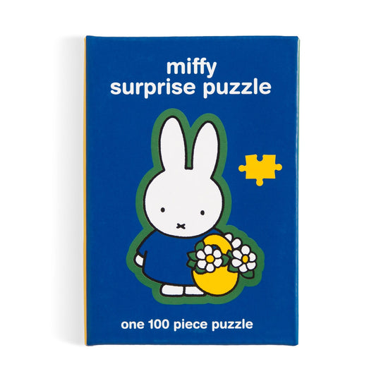 A blue box labeled "Miffy 100 Piece Surprise Puzzle" by Miffy features Miffy, a white rabbit in a blue dress holding a yellow basket with flowers. Box specifies it includes one 100-piece puzzle.