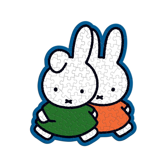 The Miffy 100 Piece Surprise Puzzle by Miffy features two cartoon bunny characters—one in a green dress, one in an orange dress—standing close together with visible puzzle piece lines on a white background.