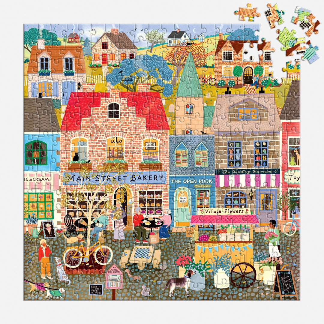 Experience the charm of Main Street Morning by Elisabeth Dorrian—a vibrant 300-piece puzzle featuring a lively village with shops, people, animals, and bikes. Unfinished pieces are visible in the top right corner.