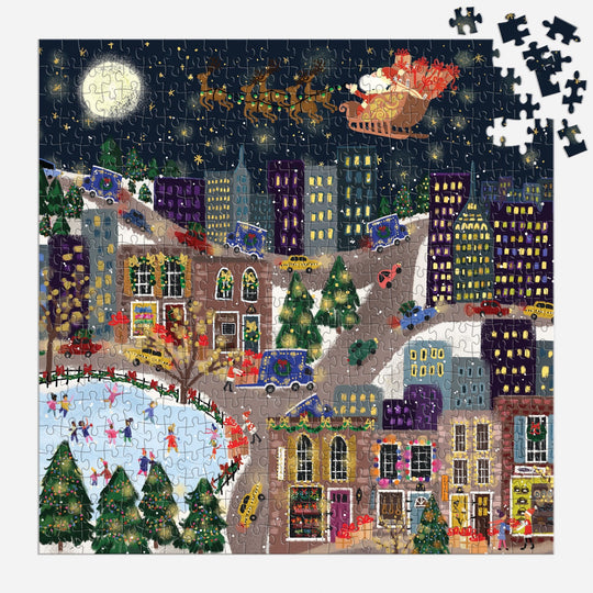 The nearly finished Joy Laforme Presentville 500 Piece Foil Puzzle by Joy Laforme displays a festive, snowy city at night with Santa flying above, glowing Christmas trees, and ice skaters; only a few pieces are missing in the upper right corner.