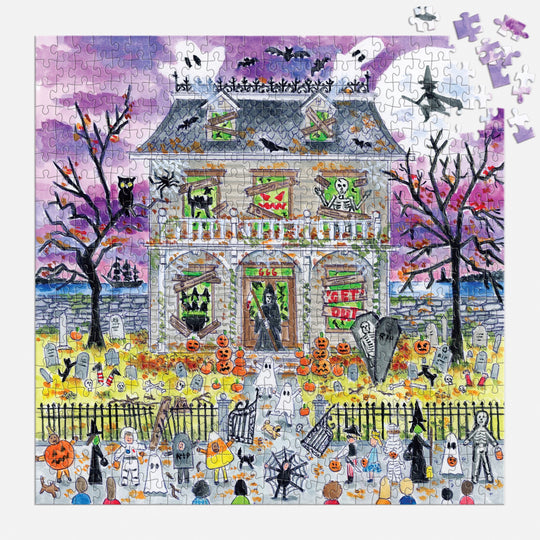 The Michael Storrings Haunted House 500 Piece Glow in the Dark Puzzle by Michael Storrings features skeletons, jack-o’-lanterns, tombstones, and trick-or-treaters—ideal for intermediate puzzlers. A few pieces are missing in the top right corner.