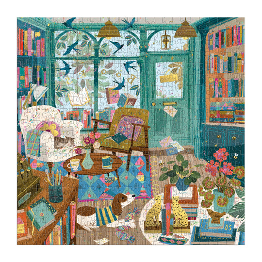 Enjoy Victoria Ball’s Bookshop Afternoon 500 Piece Foil Puzzle, featuring a vibrant living room brimming with books, plants, armchairs, a dog lounging on the floor, and birds outside—ideal for literary lovers and puzzle fans alike.