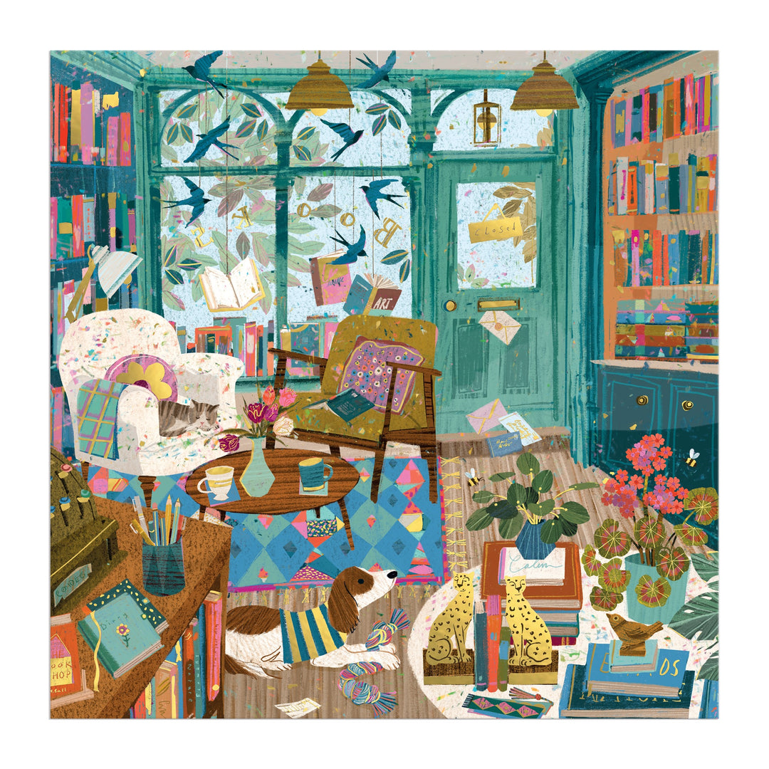 The Bookshop Afternoon 500 Piece Foil Puzzle by Victoria Ball features a cozy, colorful room with books, plants, a dog on a rug, and sunlight streaming through large windows—an inviting scene perfect for literary lovers.