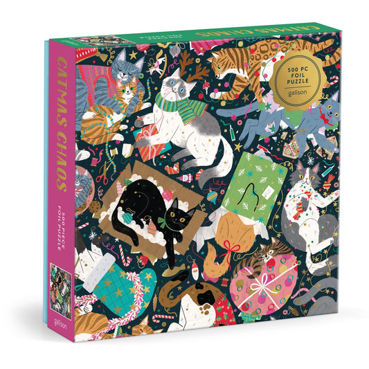 The Catmas Chaos 500 Piece Foil Puzzle by Maria Kee showcases playful cats with Christmas decorations, wrapping paper, and ribbons on a festive dark background—perfect for holiday fun.