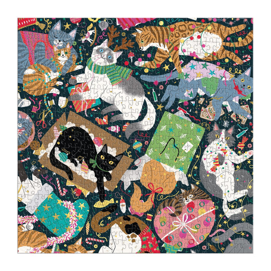 The Catmas Chaos 500 Piece Foil Puzzle by Maria Kee features playful cats with holiday decorations on a dark background. This festive and colorful cat puzzle is the perfect holiday treat for cat lovers.