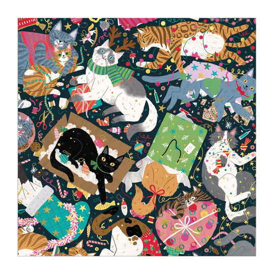 Maria Kee's Catmas Chaos 500 Piece Foil Puzzle features playful cats amid festive decorations, wrapping paper, gifts, and string lights on a dark background—perfect for holiday cat lovers and puzzle fans.