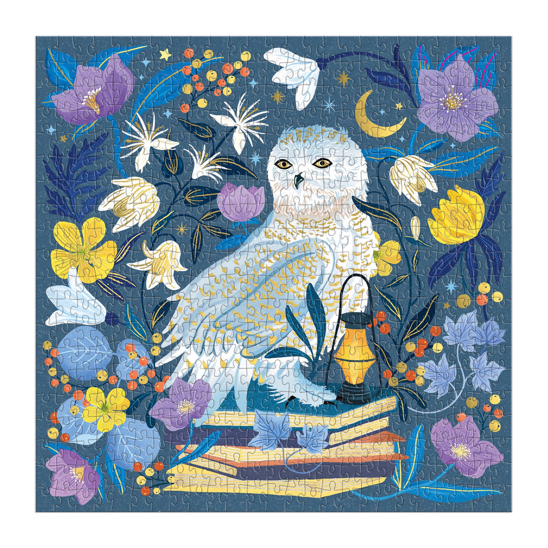 The Dawn Cooper Celestial Owl 500 Piece Foil Puzzle features a white owl surrounded by vibrant flowers, books, a lantern, and stars on a deep blue background with yellow, purple, and orange floral details.