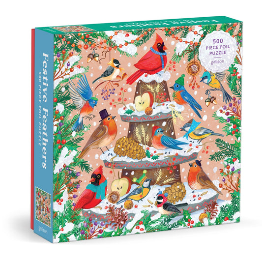 The Olga Akbarova Festive Feathers 500 Piece Foil Puzzle features cardinals and bluebirds on a snowy stand with fruit, nuts, and greenery. Subtle metallic foil accents add festive sparkle to this colorful avian-themed puzzle.