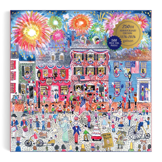 Michael Storrings Celebrate The USA 500 Piece Foil Puzzle by Michael Storrings features a vibrant street scene with patriotic outfits, American flags, fireworks, and red, white & blue decor, plus a gold label for the 250th anniversary edition.
