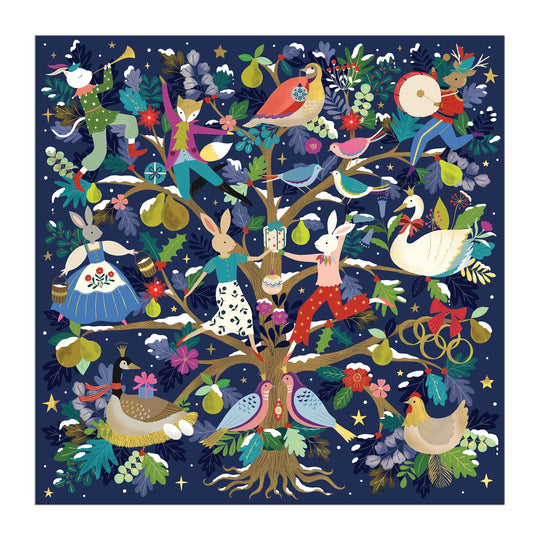 Celebrate the season with Flora Waycott’s 12 Days of Joy 500 Piece Foil Puzzle, featuring a festive scene of animals and people dancing, drumming, and singing around a pear tree adorned with birds, flowers, and stars on a dark blue background.