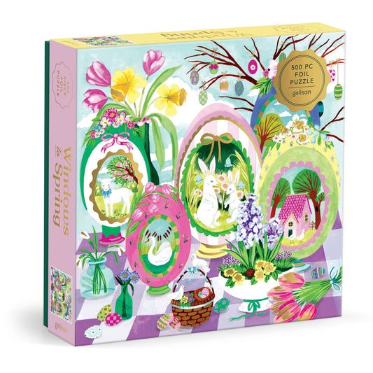 Joanna Clay’s “Windows to Spring 500 Foil Piece Puzzle” features illustrated spring scenes—flowers, bunnies, a lamb, eggs, basket, and house—in pastel colors with foil accents.