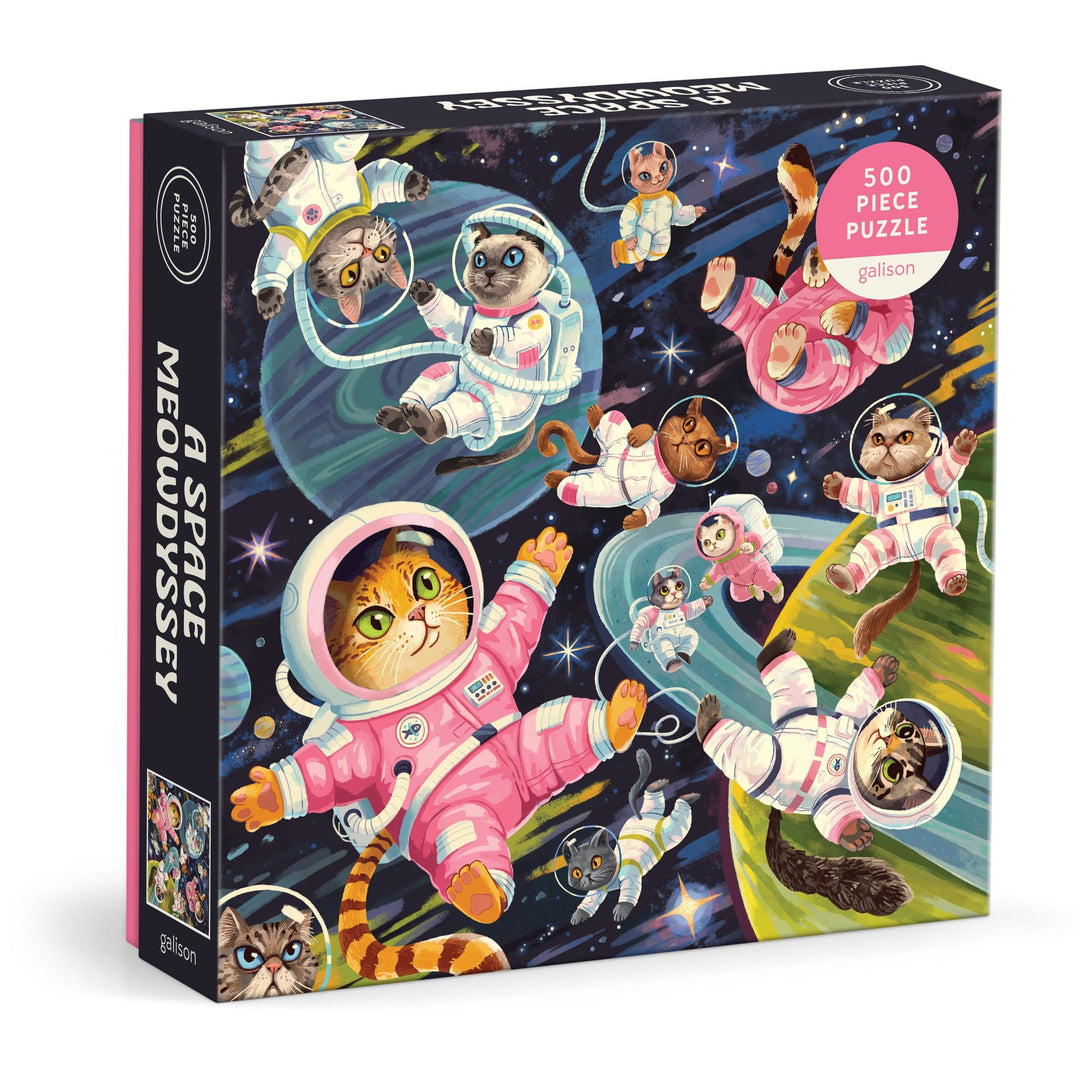 The Lucia Baertl "A Space Meowdyssey 500 Piece Puzzle" features illustrated cats in colorful space suits floating among planets and stars, offering a fun cosmic cat adventure.