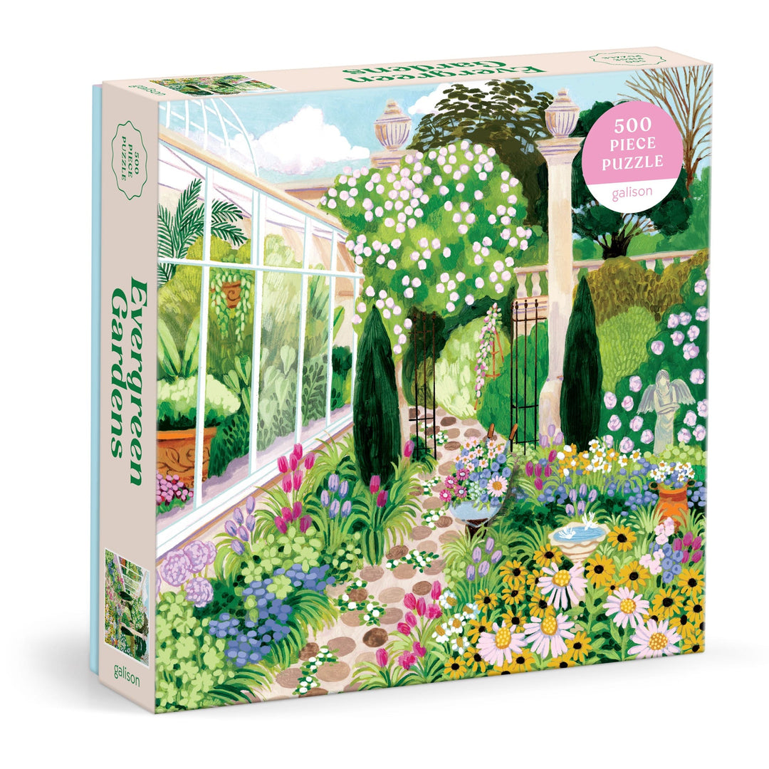 The Joanna Clay Evergreen Gardens 500 Piece Puzzle features a lush garden illustration with colorful flowers, greenery, a greenhouse, and stone columns. The pastel box highlights floral and green details.
