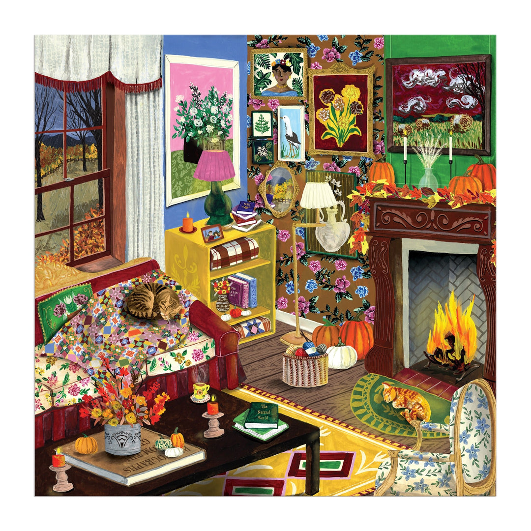 The "Fall is in the Air" 500 Piece Puzzle by Abbey Jacobs features a cozy living room with floral wallpaper, art, books, pumpkins, flowers, a cat napping on a patterned sofa by the window, and a wintry scene outside.