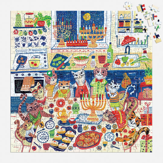 The Happy Hanukcats 500 Piece Puzzle by Anna Ivanir features cats in aprons celebrating Hanukkah in a kitchen with menorahs, lit candles, latkes, challah bread, and festive holiday decorations for a cheerful scene.