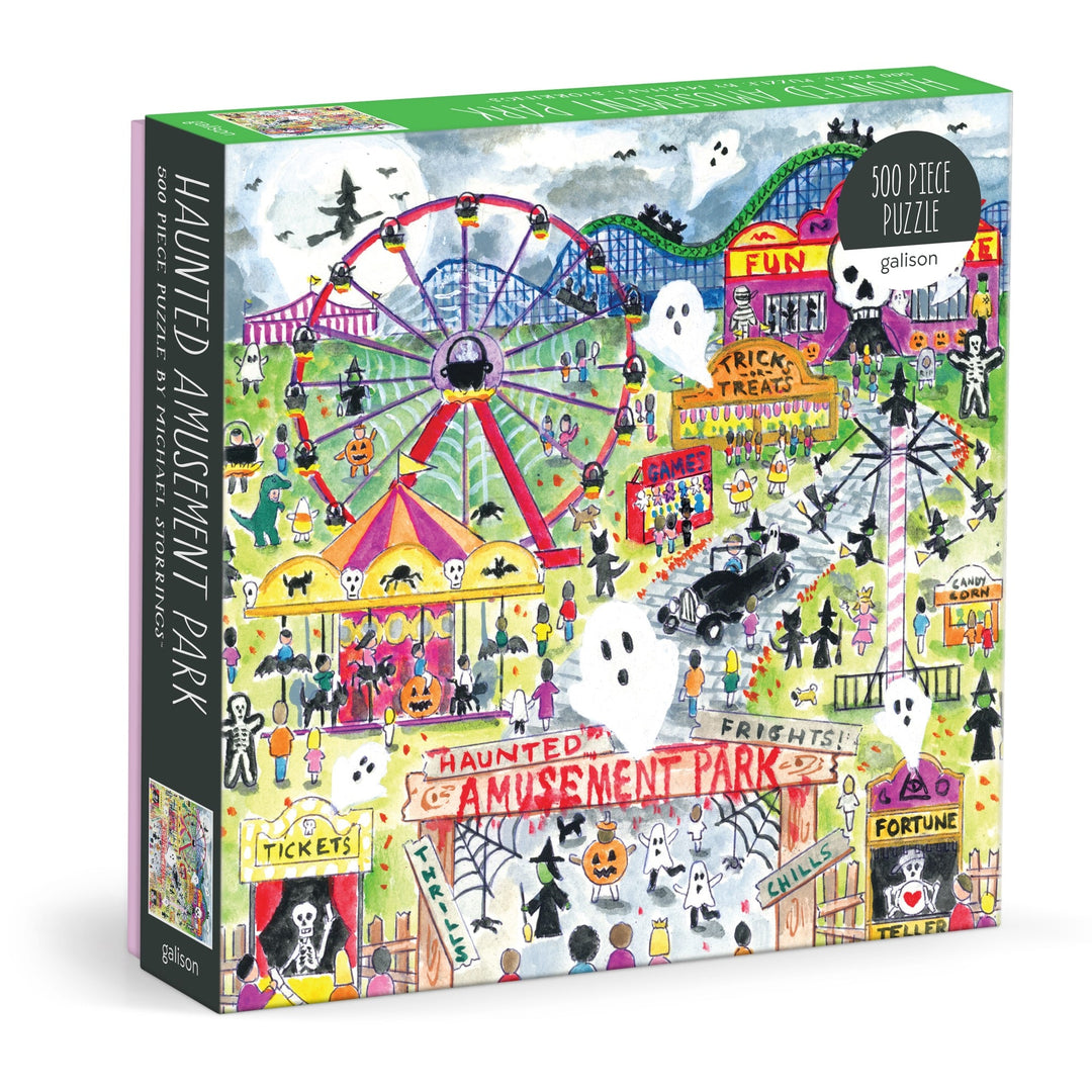 The Michael Storrings Haunted Amusement Park 500 Piece Puzzle by Michael Storrings features a vibrant haunted amusement park scene with ghosts, jack-o’-lanterns, carnival rides, creepy booths, and spooky night decorations.