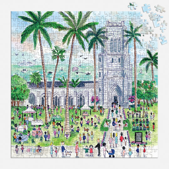 The Michael Storrings Sunday in Palm Beach 500 Piece Puzzle by Michael Storrings depicts a vibrant outdoor scene with a stone church, palm trees, people on the grass, tents, and a few unfinished puzzle pieces in the top right corner.