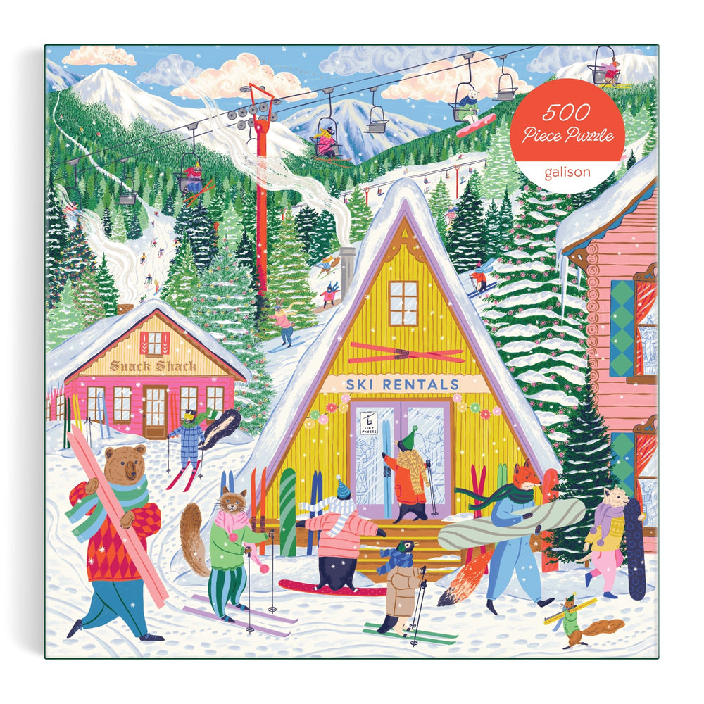 The Emily Taylor Ski Village 500 Piece Puzzle features a colorful ski resort scene with animal characters skiing, snowboarding, and renting gear at a yellow lodge, snowy mountains and a ski lift in back, and a Snack Shack on the left.