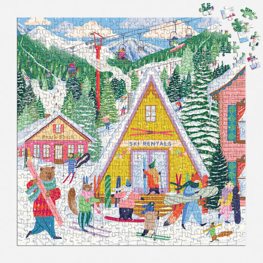 The Emily Taylor Ski Village 500 Piece Puzzle features a vibrant ski resort scene with people in winter gear by a yellow “Ski Rentals” cabin, snowy trees, and ski lifts on a mountain slope. Some pieces are missing.