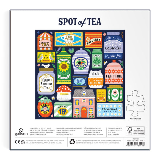 The Spot of Tea 500 Piece Puzzle by Holly Maguire features whimsical tea tins, teacups, and a teapot labeled Green Tea, Earl Grey, and Chai. A flower-filled house sits at the center on a navy blue background.