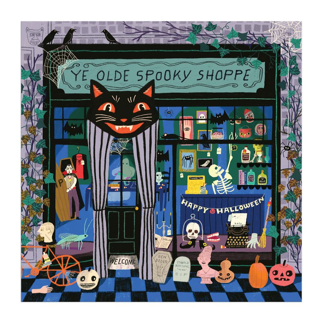 Anne Bentley’s Ye Olde Spooky Shoppe 500 Piece Puzzle features a whimsical, colorful Halloween shop with cobwebs, skeletons, witches, bats, pumpkins, potions, a black cat, and spooky items displayed in the window.