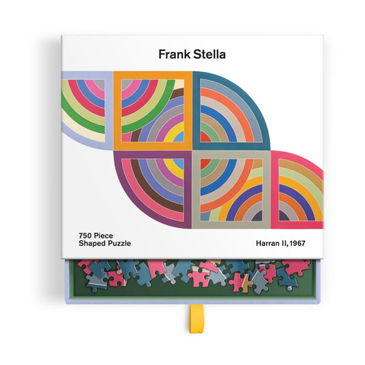 The Frank Stella Harran II 750 Piece Shaped Puzzle in Drawer Box features colorful geometric quarter-circle patterns. The open box displays puzzle pieces inside, and the puzzle is branded by Frank Stella.