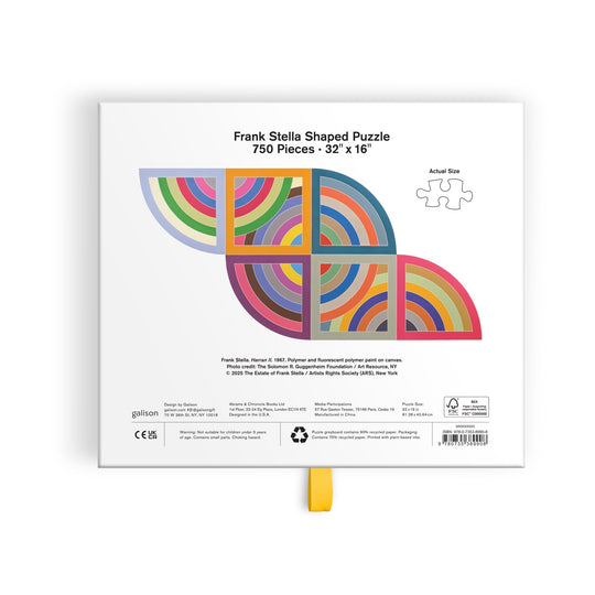 The back of the Frank Stella Harran II 750 Piece Shaped Puzzle in Drawer Box by Frank Stella showcases vibrant geometric artwork and a sample puzzle piece, along with product details. Puzzle size: 32 x 16 inches.