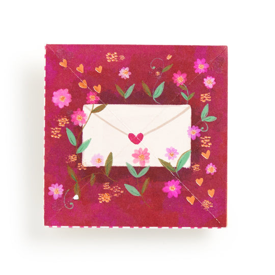 The Joy Laforme Charm Cards feature a square red design adorned with pink flowers, green leaves, orange hearts, and a central envelope illustration sealed with a red heart sticker.
