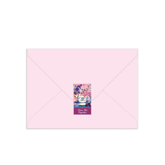 The Joy Laforme Art of the Table Greeting Card Puzzle by Joy Laforme comes in a light pink envelope with a back flap sticker, adorned with pink and blue floral art and “Peace, Not Together” at the bottom.