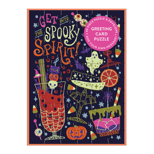 The Get into the Spooky Spirit Greeting Card Puzzle by Camille Chew is a colorful Halloween-themed puzzle featuring festive drinks, a ghost, pumpkin, eyeballs, and cake. The packaging serves as a greeting card with space for your message.