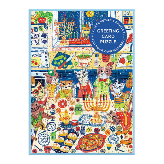 Anna Ivanir’s “Happy Hanukcats Greeting Card Puzzle” features festive felines in colorful outfits celebrating Hanukkah with food, menorahs, dreidels, and decorations in a kitchen. Blue circle says: Interactive Puzzle Hanukkah Greeting Card.