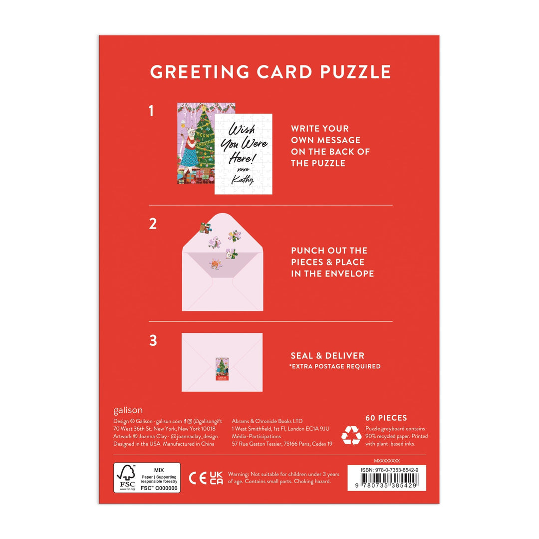 Back of Joanna Clay’s Meowy Christmas Greeting Card Puzzle box shows three steps: write a message, punch out 60 puzzle pieces, and mail. Features cat-themed art, sample card, envelope images, and festive red packaging.