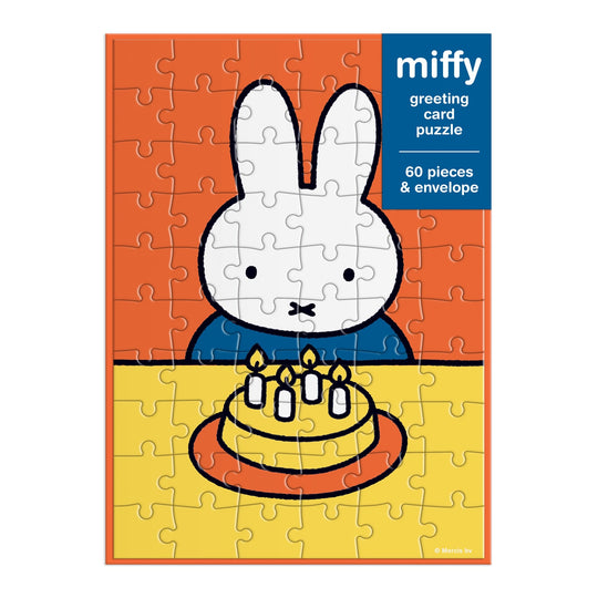 The Miffy Birthday Greeting Card Puzzle by Miffy is a 60-piece puzzle showing Miffy the bunny at a table with a birthday cake topped with four candles, set against an orange background.