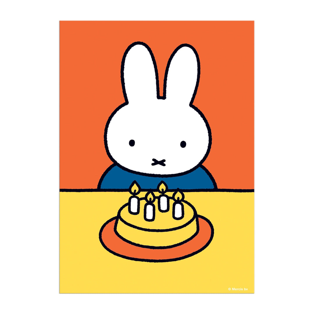 The Miffy Birthday Greeting Card Puzzle by Miffy features a white cartoon rabbit with upright ears sitting at a yellow table with a birthday cake and five lit candles, set against an orange background in a simple, colorful style.