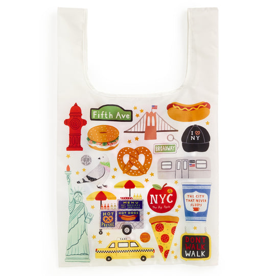 The Big Apple Packable Nylon Tote Bag by Holly Maguire is a lightweight, water-resistant white tote featuring colorful NYC icons—taxi, pizza slice, hot dog, pretzel, Statue of Liberty, fire hydrant, subway train, and city signs.