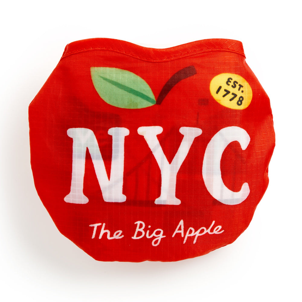 The Big Apple Packable Nylon Tote Bag by Holly Maguire is a red, apple-shaped, lightweight bag featuring bold white NYC letters, a green leaf, “The Big Apple,” and an EST. 1778 yellow circle—crafted from water-resistant material for lasting durability.