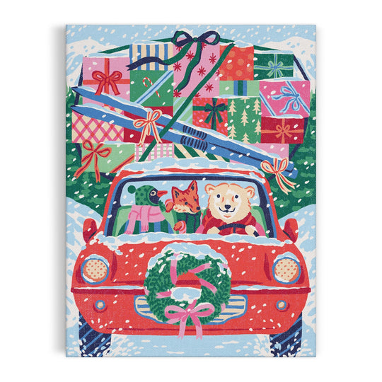 Emily Taylor’s Christmas Joyride 9 x 12" Paint by Number Kit features a red car with gifts and skis on the roof, snowy trees in the background, and a smiling bear, fox, and dog inside as they drive through a wintry landscape.