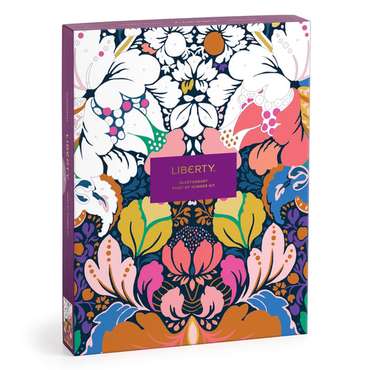 The Liberty London Liberty 9 x 12 Paint by Number Kit Glastonbury features a vibrant floral design in pink, blue, green, yellow, orange, white, and purple with a central purple label and premium acrylic paints.