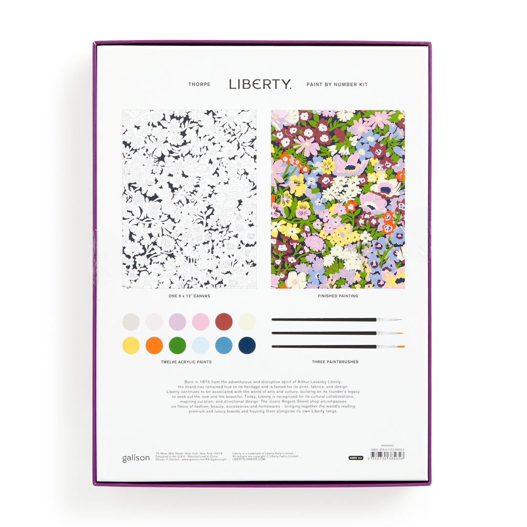 The back of the Liberty London 9 x 12 Paint by Number Kit Thorpe shows a black-and-white numbered canvas, completed floral painting, 12 acrylic paint pots, 3 brushes, product info, and text: LIBERTY PAINT BY NUMBER KIT.
