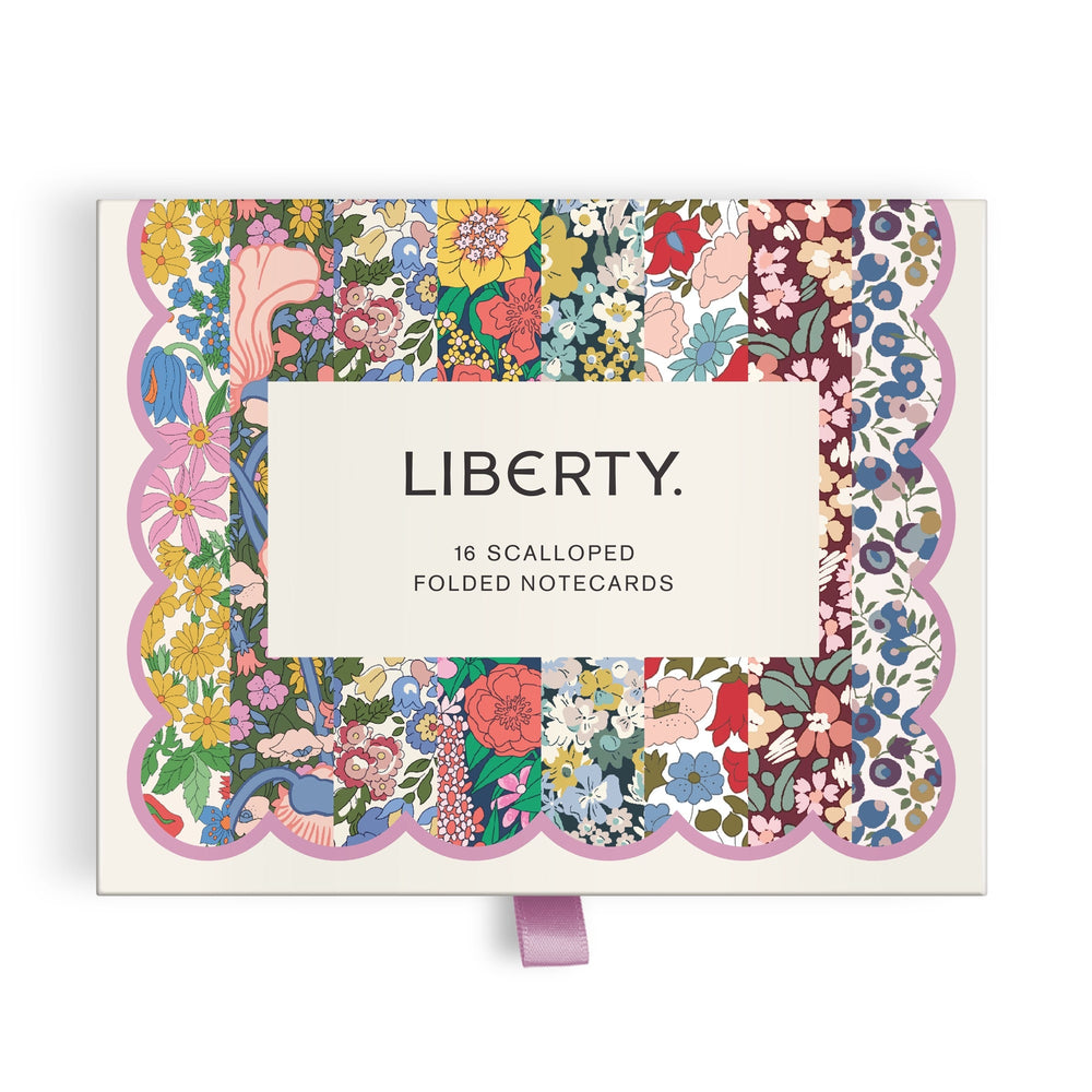 The Liberty Premium Notecard Set by Liberty London features 16 scalloped folded cards with multicolored floral patterns and a lavender ribbon pull tab. A white label with LIBERTY. is centered on the box.