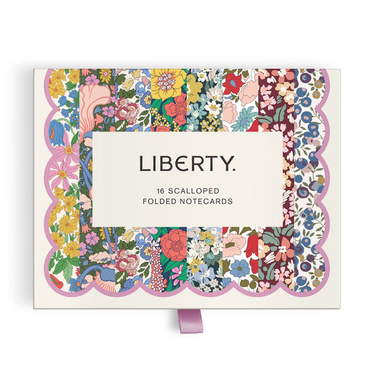 The Liberty Premium Notecard Set by Liberty London features 16 scalloped folded cards with multicolored floral patterns and a lavender ribbon pull tab. A white label with LIBERTY. is centered on the box.