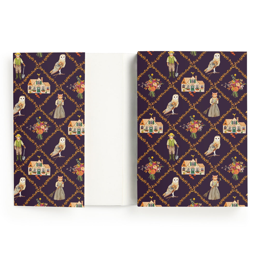 The Cottage Cats A5 Premium Notebook by Anja Riebensahm features a dark purple cover with white owls, dressed-up cats, flowers, houses, and vintage-clad children in gold diamond frames. The inside cover is plain white.