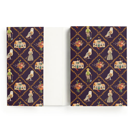 The Cottage Cats A5 Premium Notebook by Anja Riebensahm features a dark purple cover with white owls, dressed-up cats, flowers, houses, and vintage-clad children in gold diamond frames. The inside cover is plain white.