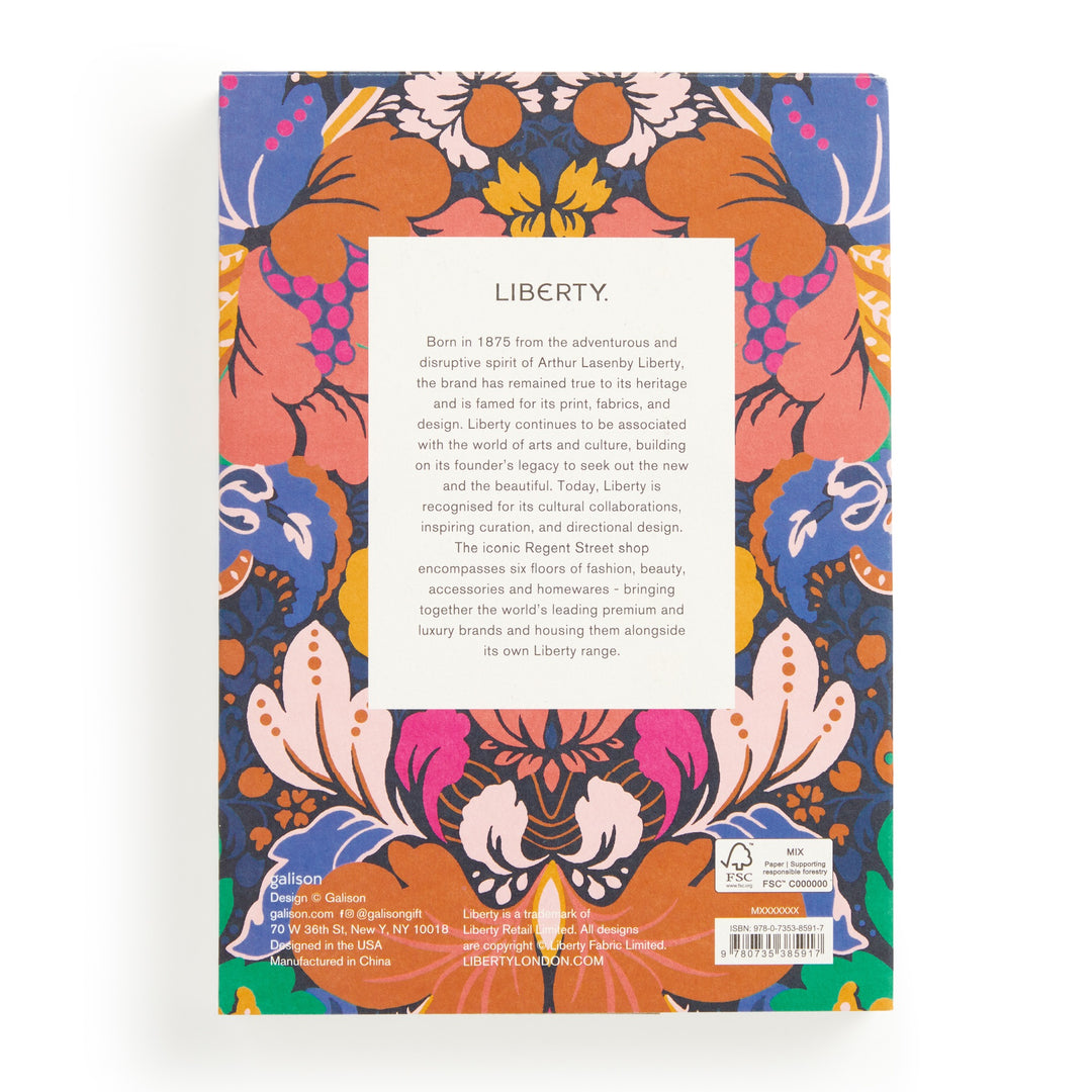 The back cover of the Liberty Glastonbury Premium A5 Notebook by Liberty London has a central white rectangle with text, framed by a vibrant floral pattern in orange, pink, blue, and purple. Barcode and publisher info are shown at the bottom.