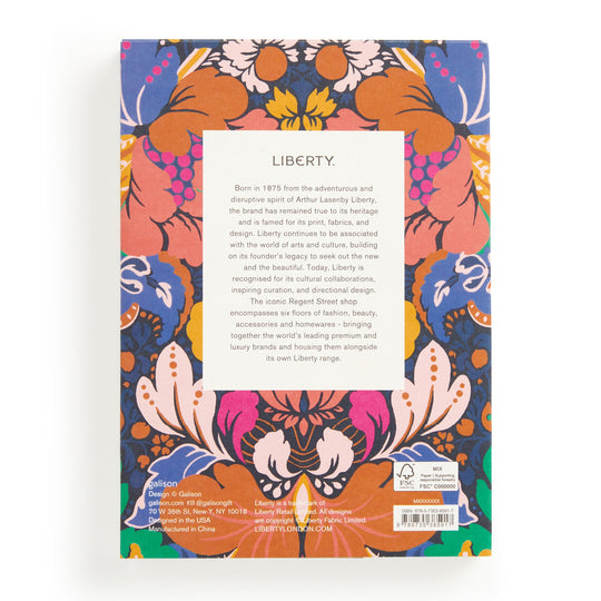 The back cover of the Liberty Glastonbury Premium A5 Notebook by Liberty London has a central white rectangle with text, framed by a vibrant floral pattern in orange, pink, blue, and purple. Barcode and publisher info are shown at the bottom.