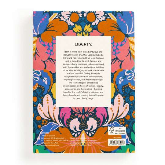 The Liberty Glastonbury Premium A5 Notebook by Liberty London has a back cover with a vibrant blue, orange, pink, and yellow floral and leaf design and a centered white box featuring black text about the notebook.