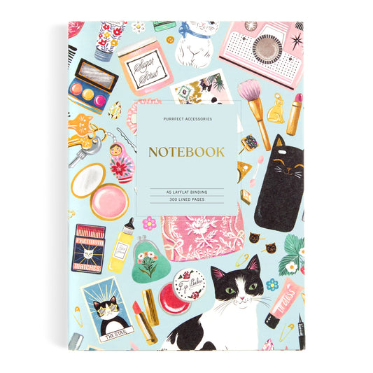 The Christine De Carvalho Purrfect Accessories Premium A5 Notebook features feline, makeup, book, and perfume illustrations on a light blue cover. Includes 300 lined pages and a Notebook center label—perfect for sophisticated stationery lovers.