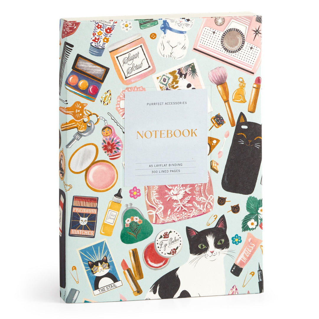 The Purrfect Accessories Premium A5 Notebook by Christine De Carvalho features colorful cats, makeup, perfume, and cute accessories on the cover—a chic stationery item labeled Notebook and Perfect Accessories for your desk.