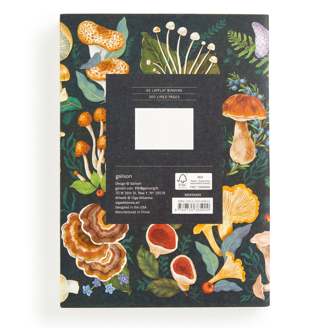 The World of Mushrooms Premium A5 Notebook by Olga Akbarova features mycological illustrations of colorful mushrooms and green leaves on a black cover, with a central label noting 300 lined pages and manufacturer details.
